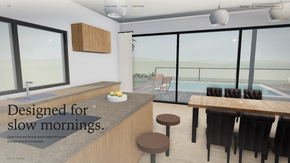 Living room with a sofa facing a lit fireplace and floor-to-ceiling glass